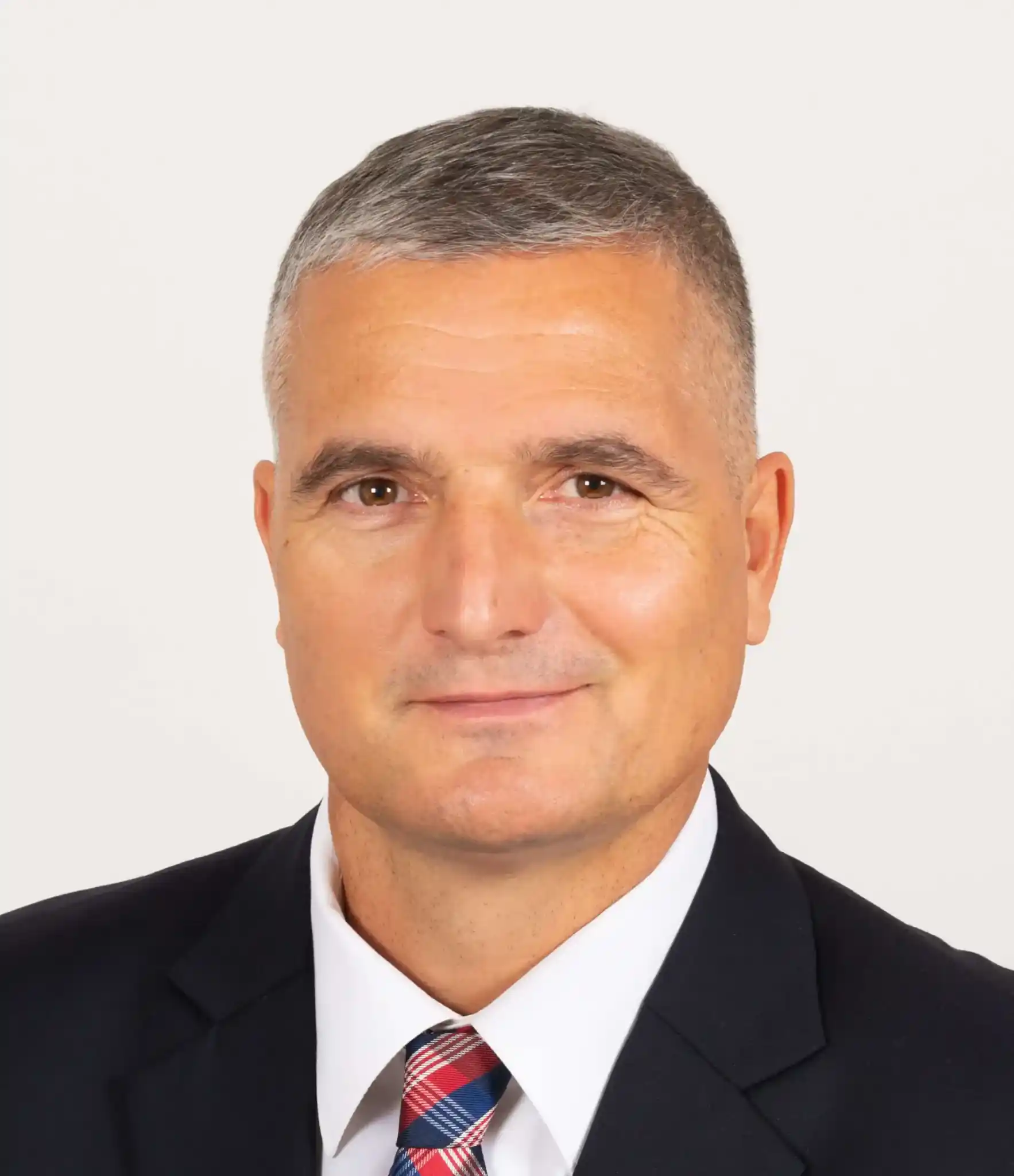Man in suit with short gray hair.